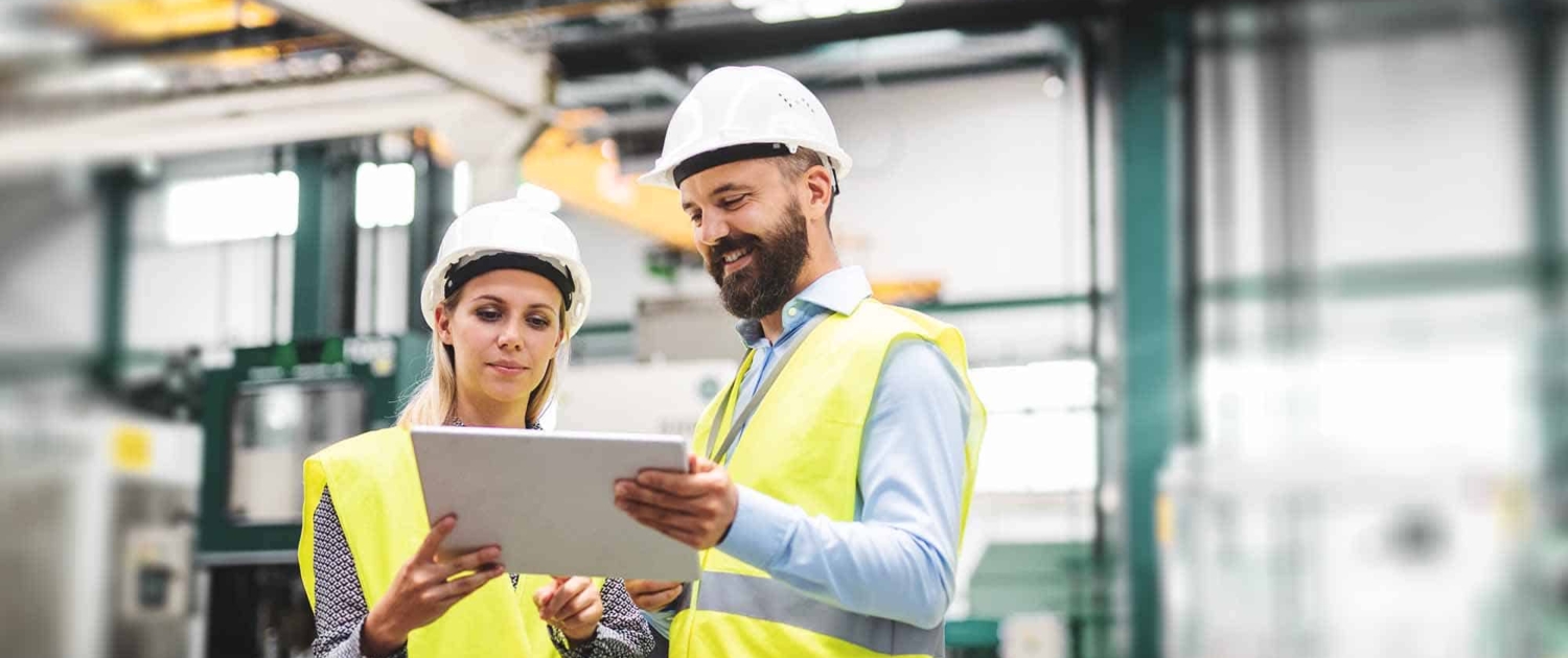 A portrait of an industrial man and woman engineer with tablet in a factory, talking_