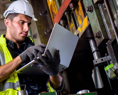 Close up view of a maintenance worker on a laptop
