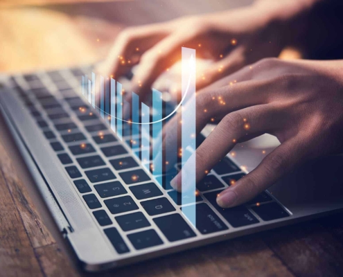 Close up view of person typing on keyboard with graph